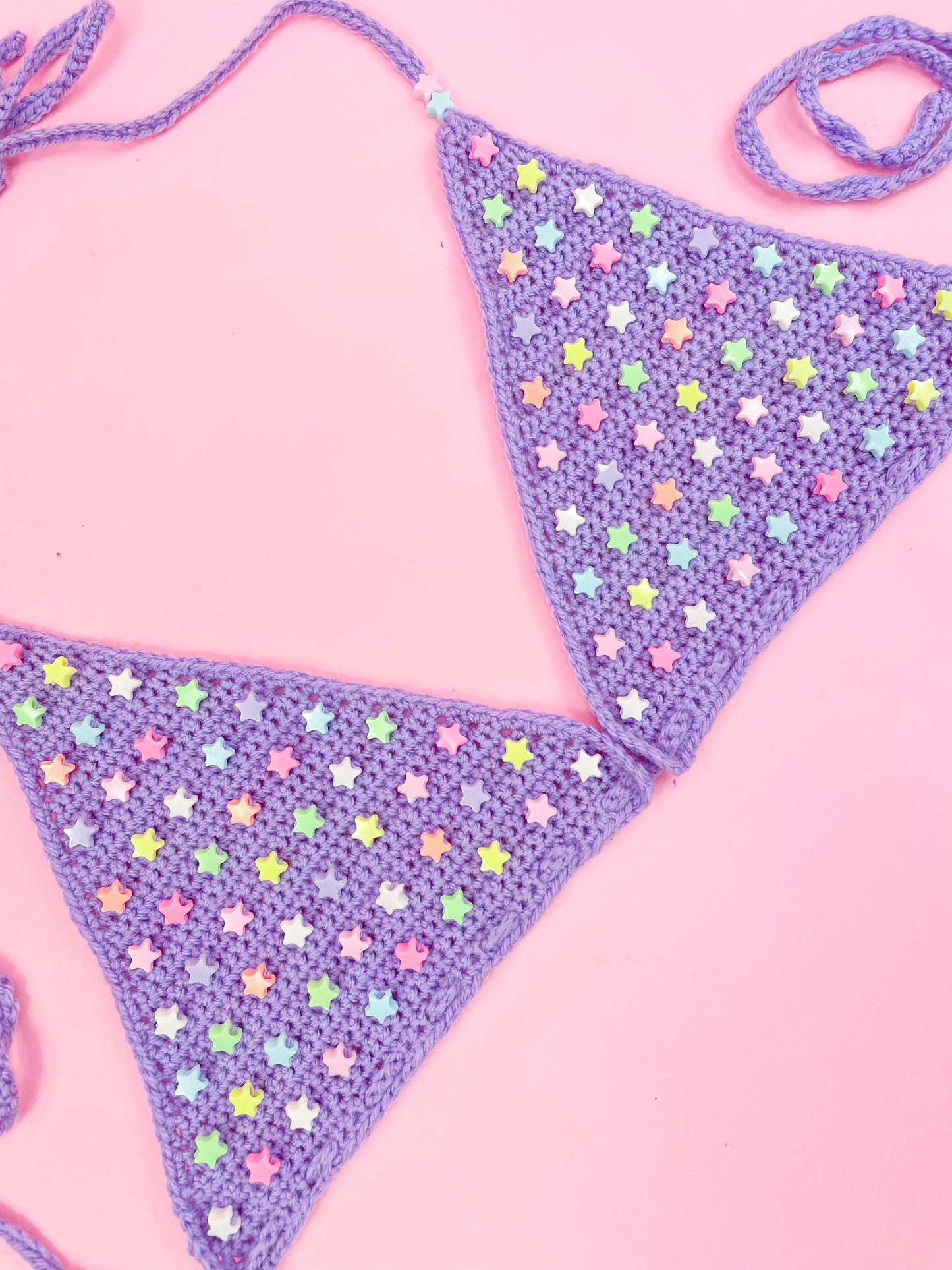 Flat lay side view of a star beaded bralette in lilac showing the crochet stitches and details.