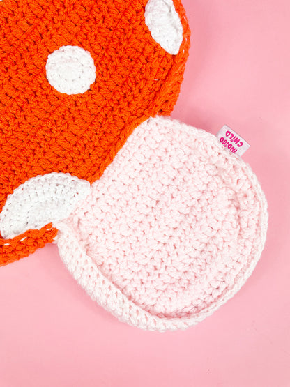 Close up of the bottom of a mushroom shaped bag showing the crochet stitches and an Indigo Child label attached to the side.