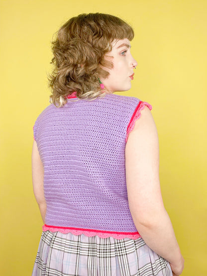 Back view of a woman wearing a lilac vest with pink edges and a matching purple kilt against a yellow background.